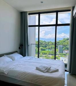 a bedroom with a bed with a large window at Summer Studio Apartment at Kota Kinabalu City Centre in Kota Kinabalu