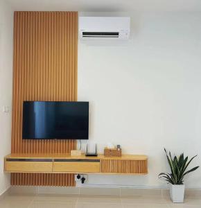 a living room with a television on a wooden wall at Summer Studio Apartment at Kota Kinabalu City Centre in Kota Kinabalu