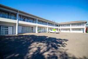 een gebouw met een auto geparkeerd op een parkeerplaats bij Bayside Hotel Pinetown in Pinetown