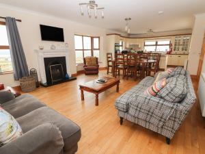 a living room with two couches and a table and a fireplace at Lackamore in Lahinch