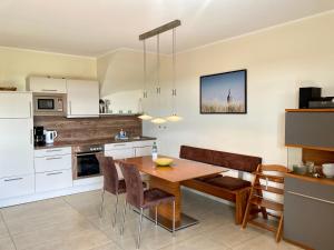 a kitchen with a wooden table and chairs at Ferienhaus Grodenblick Strandflieder Whg. 2 in Wangerooge