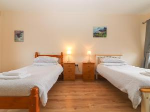 two twin beds in a room with two lamps on dressers at Lackamore in Lahinch