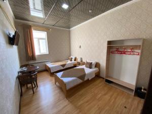 希瓦的住宿－Polvon Ota Hotel，卧室配有一张床和一张桌子