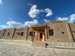 a large brick building with a door on the side at Polvon Ota Hotel in Khiva