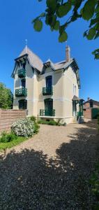 ein großes weißes Haus mit grünen Rollläden in der Unterkunft Villa Simple Abri in Verneuil d’Avre et d’Iton