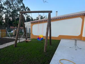 a swing set in a yard next to a house at Quinta da nogueira 