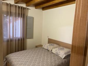 a bedroom with a bed with two pillows and a window at Quinta da nogueira 