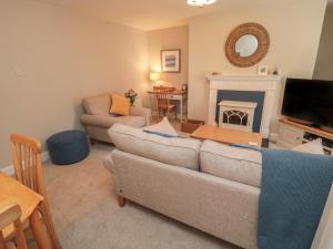 a living room with a couch and a fireplace at Charter's Cottage in Berwick-Upon-Tweed