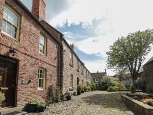 a courtyard of an old brick building with potted plants at Charter's Cottage in Berwick-Upon-Tweed