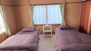 two beds in a small room with a window at GuestHouse AZMO - Vacation STAY 84356v in Matsue