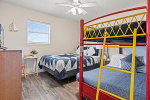 a bedroom with two bunk beds and a ceiling fan at Oceanfront 2BR Cottage w Sunsets Views Comfy and Pet and Family Friendly in Freeport