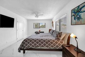 a bedroom with a bed and a flat screen tv at Modern Lux Pool Home Upscale, Spacious and Comfy in Kendall