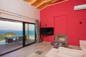 soggiorno con parete rossa di Sivota Lefkas Luxury Villas a Sivota