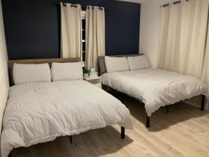 two beds with white sheets in a room at The California - On Top of San Diego in a Hot Tub in San Diego