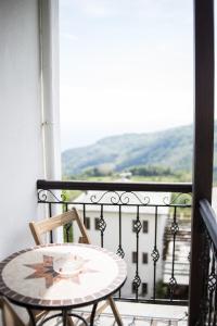 a table and chair on a balcony with a view at Φιλυρέα - Ενοικιαζόμενα Δωμάτια in Zagora