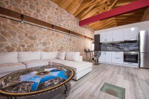 a living room with a white couch and a stone wall at Sivota Lefkas Luxury Villas in Sivota