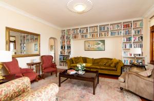 a living room with a couch and chairs and bookshelves at Ridgeview Lodge in Durban
