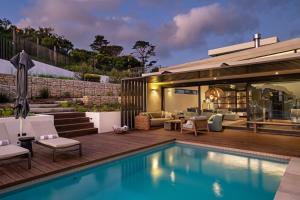 un patio trasero con piscina y una casa en Vyn Guest House Hout Bay en Hout Bay