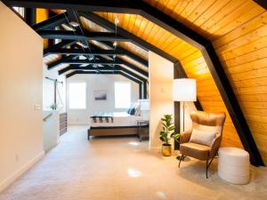 a living room with a wooden ceiling and a chair at Alpine Lodge in Glacier