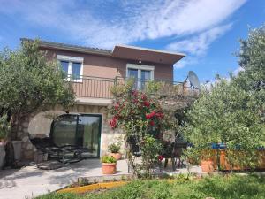 a house with a balcony and flowers in front of it at Holiday House Mablo with pool & jacuzzi in Šibenik