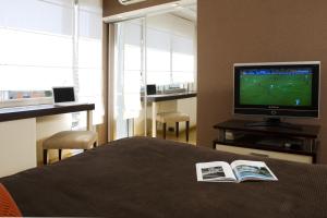 a bedroom with a television and a book on a bed at Uriburu 1756 by Ayres Apartments Recoleta in Buenos Aires