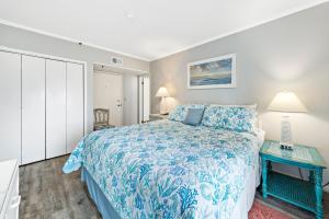 Un dormitorio con una cama azul y blanca y una mesa en Plantation Dunes 5316 Shore to Please, en Gulf Shores