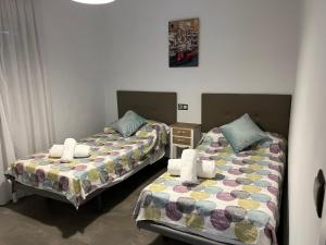 dos camas sentadas una al lado de la otra en una habitación en PISO TURÍSTICO ZAIDA, en Almodóvar del Río