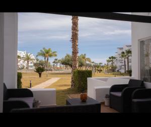 a living room with a view of a park with palm trees at Vista Verde in Murcia