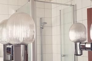 twee lampen in een badkamer met een douche bij Oma Lina Haus - 4 SZ 2 Bäder großer Garten und Infrarot-Sauna in Greifenstein