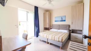 a bedroom with a bed and a large window at Hotel Angelo in Caorle