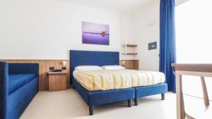 a bedroom with a blue bed and a blue couch at Hotel Angelo in Caorle +52 photos