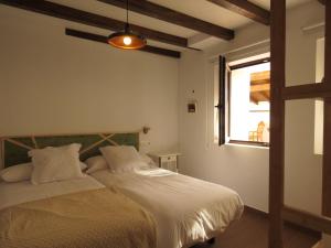 a bedroom with a bed with white sheets and a window at LA LÍNEA DEL MAR in Trasierra