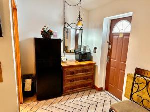 a kitchen with a black refrigerator and a wooden dresser at Buffalo Chip's Ranch House Motel in Bonita Springs +30 photos