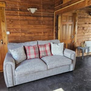 a couch in a room with a wooden wall at Hillhaven Lodge in Inverness