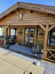 a wooden building with potted plants in front of it at Hillhaven Lodge in Inverness