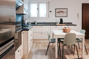 a kitchen with a table and chairs and a sink at Tra le case di Reggio - Passo Buole in Reggio Emilia +9 photos