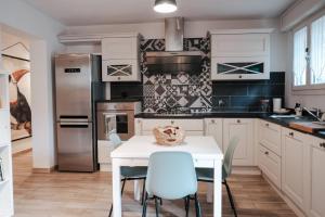 a kitchen with a white table and blue chairs at Tra le case di Reggio - Passo Buole in Reggio Emilia