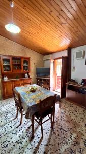 Habitación con mesa en una cocina con techo de madera en CASA VACANZE DON VARTULIDDU, en Scicli