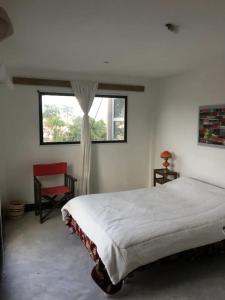 um quarto com uma cama, uma janela e uma cadeira em Alojamiento cerca de la costa em Mar del Plata
