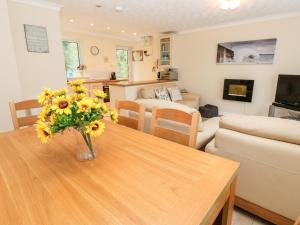a living room with a vase of flowers on a table at 17 River Banks in Liskeard