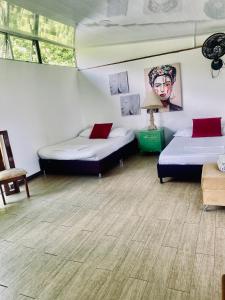 two beds in a room with wooden floors at Cabaña Tierra Verde eje Cafetero in Manizales