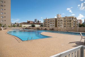 a swimming pool in the middle of a building at Enseada - Vista Espetacular, Churrasqueira e Lazer in Guarujá