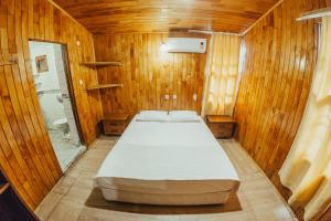 ein Schlafzimmer mit einem Bett in einem Holzzimmer in der Unterkunft Kadir's Family House in Olympos