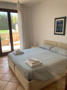 1 dormitorio con 1 cama con 2 toallas en Villa MarLu, en Bisceglie