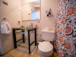 a bathroom with a toilet and a sink and a mirror at Tupa Hotel in Hanga Roa +37 photos