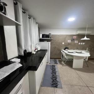 a kitchen with a sink and a table in it at STUDIO 303 | WIFI 600MB | RESIDENCIAL JC, um lugar para ficar. in Belém