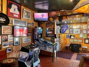 a room with a pinball machine and a video game at Buffalo Chip's Ranch House Motel in Bonita Springs
