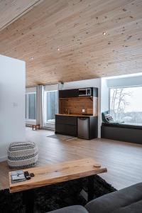 a living room with a wooden ceiling and a table at Unic loft Sapa - Massif Charlevoix, Mont-St-Anne in Saint-Joachim