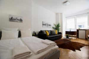 una camera con un grande letto bianco e un divano di Standard Apartment by Hi5 - Petőfi 12 a Budapest