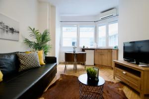 un soggiorno con divano nero e una cucina di Standard Apartment by Hi5 - Petőfi 12 a Budapest